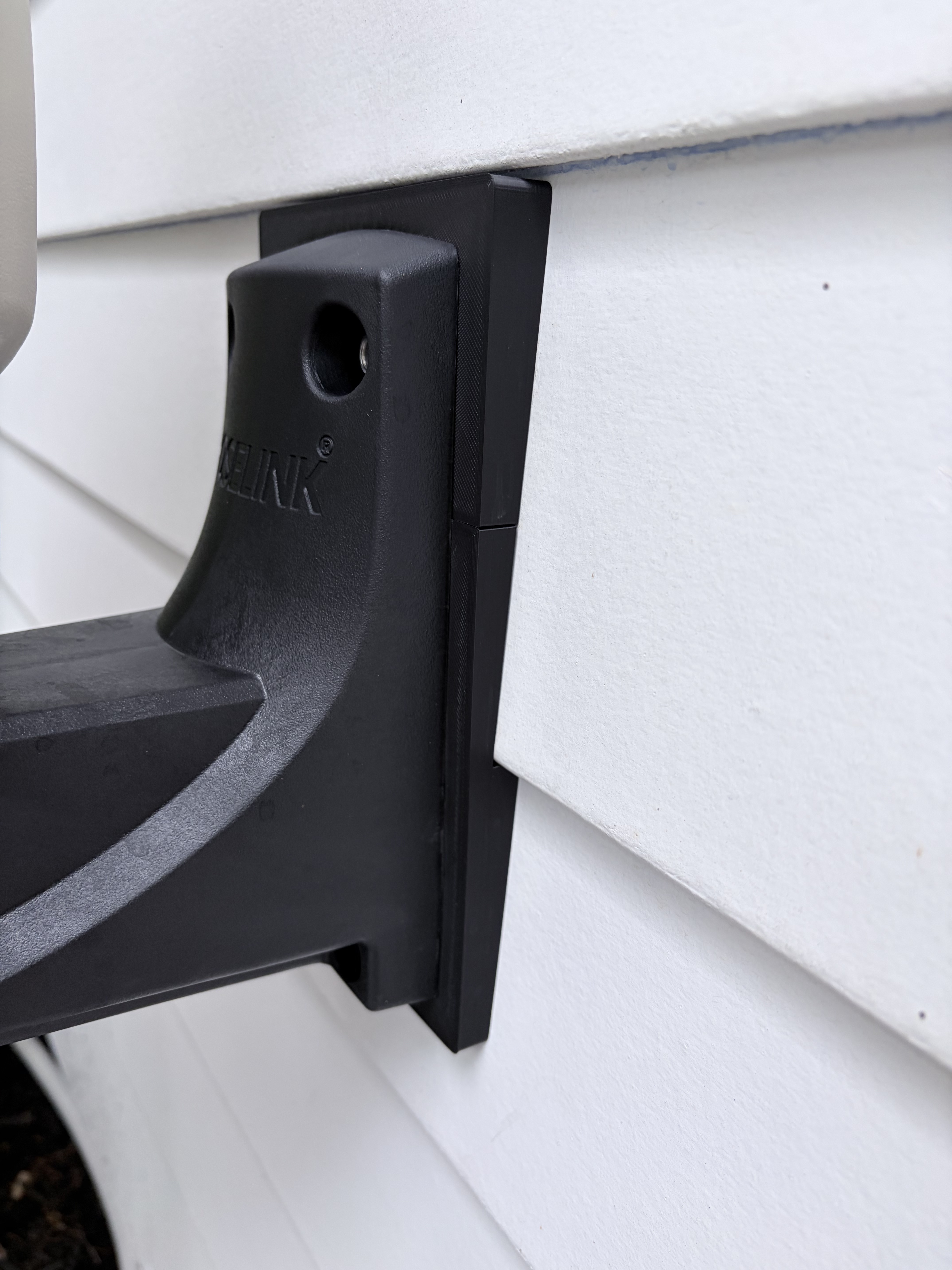 Close-up of the bracket edge sitting perfectly flush against the siding profile